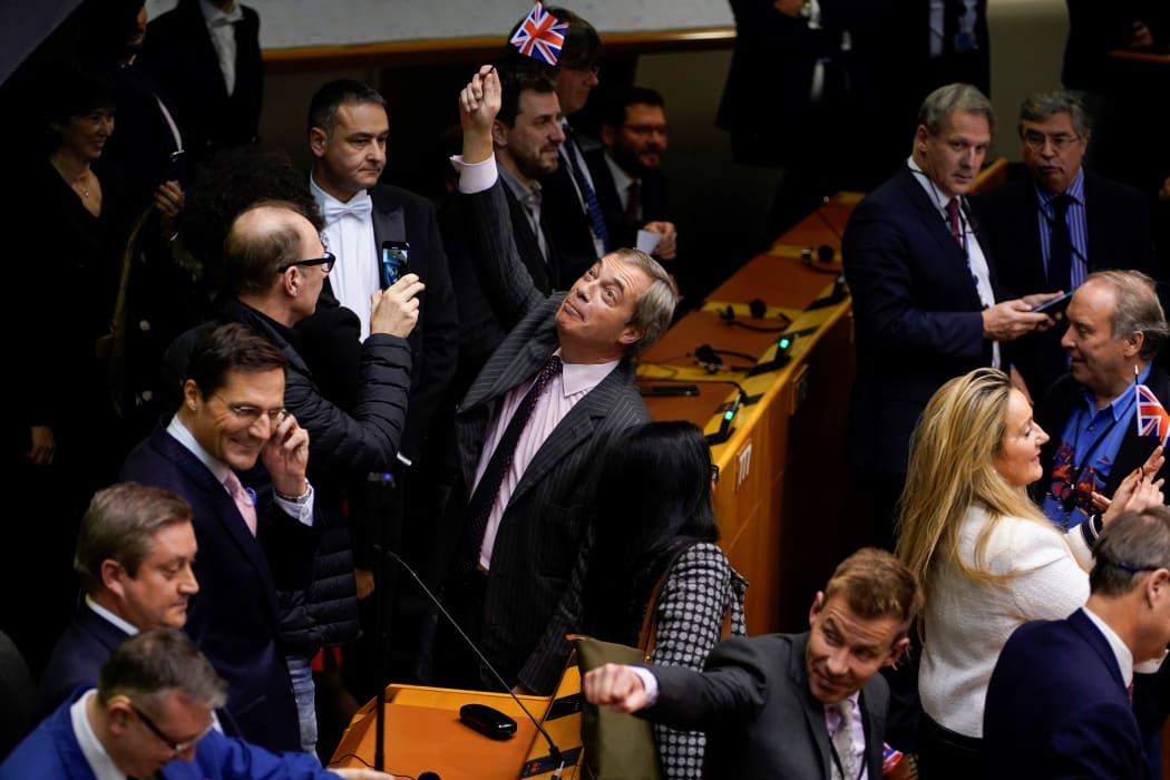 Britain's Brexit Party leader Nigel Farage holds up a small Union Jack in the European Parliament following a vote to ratify the  Brexit deal