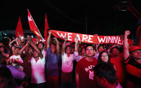 Supporters of Myanmar opposition leader Aung San Suu Kyi's party cheer as they watch polling station counts on a giant screen outside the party headquarters in Yangon.