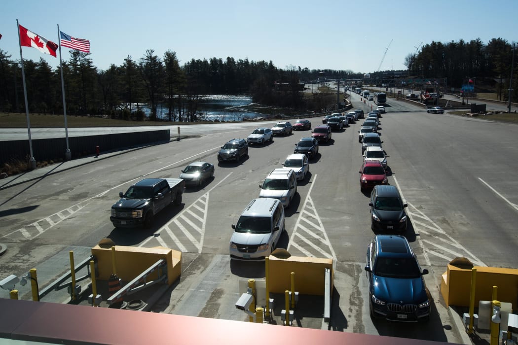 Vehicles wait at the Canadian border after the US/Canada border has been closed to all non-essential travel in Lansdowne, Ontario, on March 22, 2020.