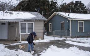 A Waco, Texas, resident clears snow from his driveway on 17 February 2021.