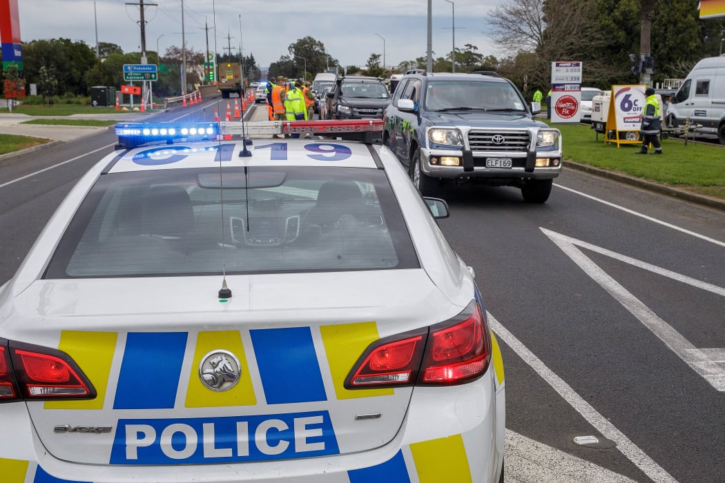 Police and military personnel check vehicles leaving the city at a COVID-19 check point setup at the southern boundary in Auckland on August 14, 2020.