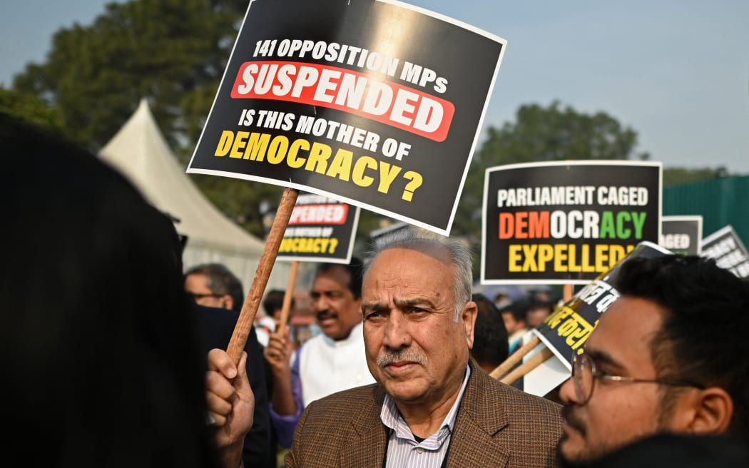 Members of Parliament hold placards as they take part in a protest march in New Delhi on December 21, 2023, against the suspension of lawmakers belonging to an opposition grouping of 26 parties dubbed INDIA -- the Indian National Developmental Inclusive Alliance -- formed to fight general elections slated for early next year. More than half of all opposition lawmakers have been barred from the ongoing session of India's parliament for demanding a debate into a protest last week in which a smoke canister was released in the legislature.