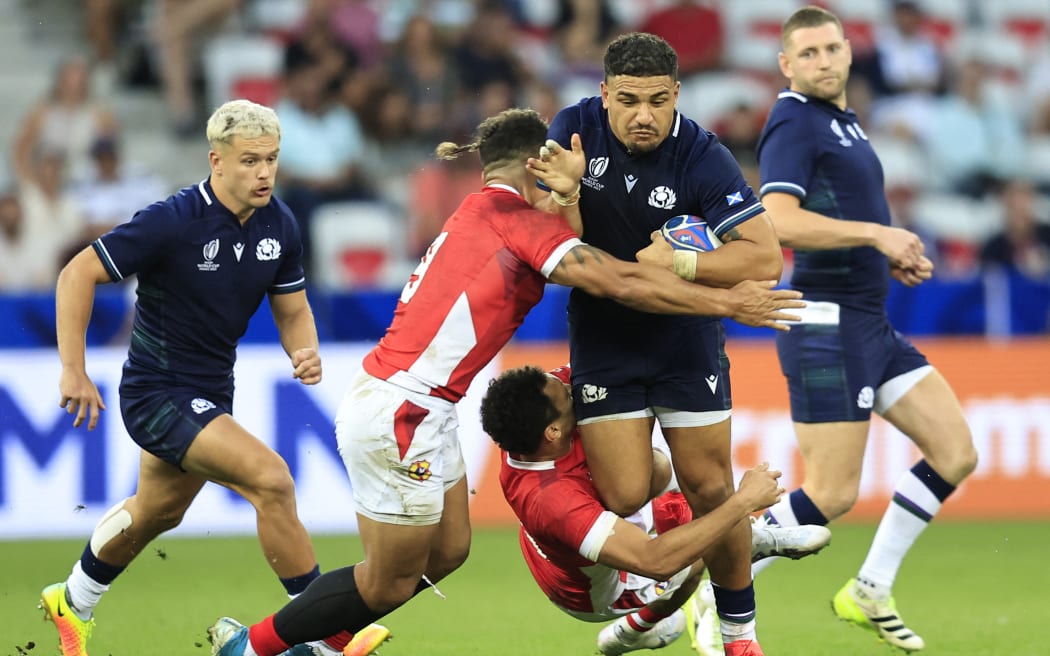 Scotland's inside centre Sione Tuipulotu (C) is tackled by Tonga's scrum-half Augustine Pulu  (L) during the France 2023 Rugby World Cup Pool B match between Scotland and Tonga at Stade de Nice in Nice, southern France on September 24, 2023. (Photo by Valery HACHE / AFP)