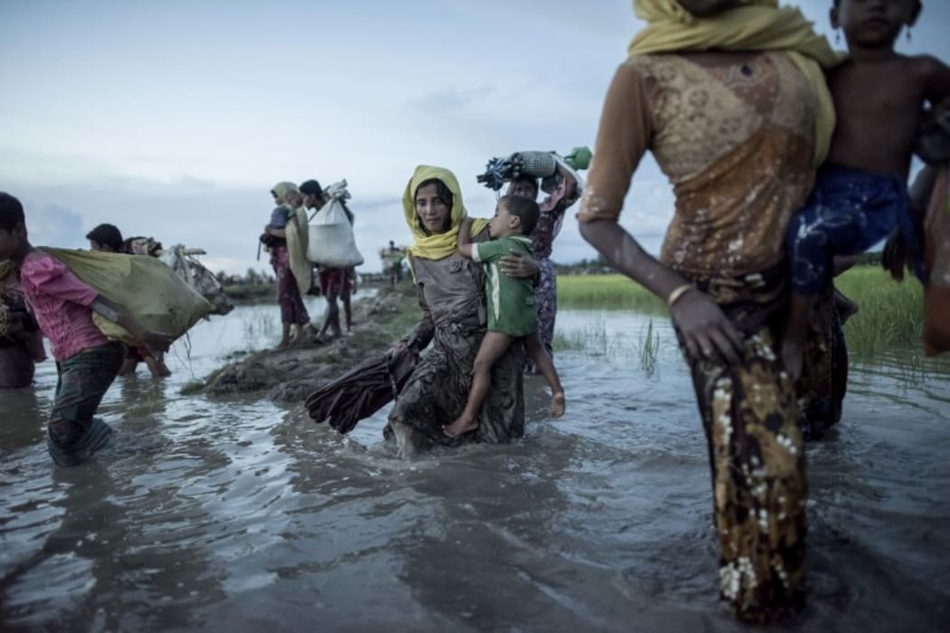 Rohingya refugees wade after crossing the Naf river from Myanmar into Bangladesh.