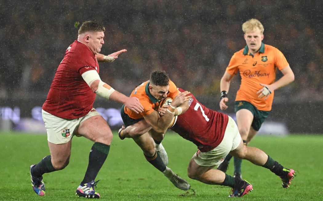 Nic Whiteof Australia is tackled by Tom Curry and Tadhg Furlong of the Lions during the Third Test, 2025.