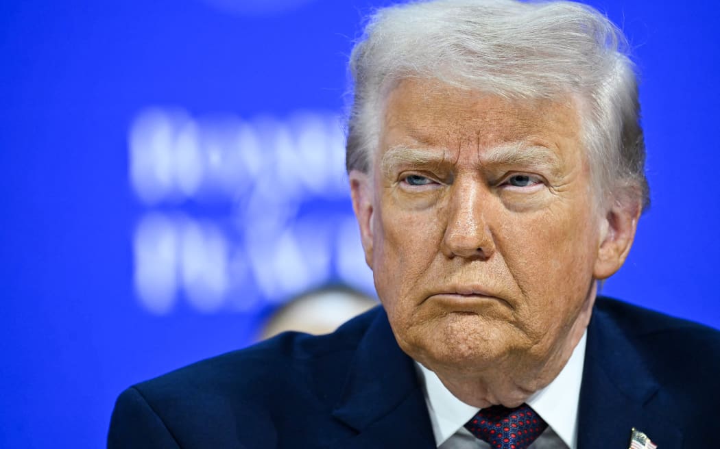 US President Donald Trump reacts at the "Board of Peace" meeting during the World Economic Forum (WEF) annual meeting in Davos on January 22, 2026. US President Donald Trump will show off his new "Board of Peace" at Davos on January 22, 2026 burnishing his claim to be a peacemaker a day after backing off his own threats against Greenland. Originally meant to oversee the rebuilding of Gaza after the war between Hamas and Israel, the board's charter does not limit its role to the Strip, and has sparked concerns that Trump wants it to rival the United Nations. (Photo by Mandel NGAN / AFP)