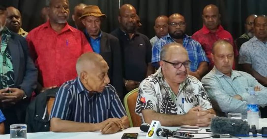 Papua New Guinea Prime Minister Peter O'Neill (seated, centre) announces his resignation, handing over to Sir Julius Chan (seated, left) 27 May 2019