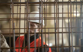 A file photo shows a construction worker selecting steel mesh for concrete reinforcement