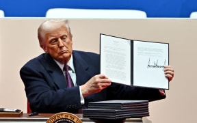 US President Donald Trump signs executive orders during the inaugural parade inside Capital One Arena, in Washington, DC, on 20 January, 2025.