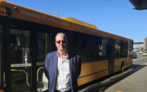Auckland Transport principal service network planner Dave Hilson at the Newmarket bus station next an Outerlink bus.