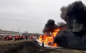 This video grab taken from a handout footage released by the Russian Emergencies Ministry on 1 April, 2022 shows firemen working to extinguish a fire at a Rosneft fuel depot in the town of Belgorod, some 40km from Russia's border with Ukraine.
