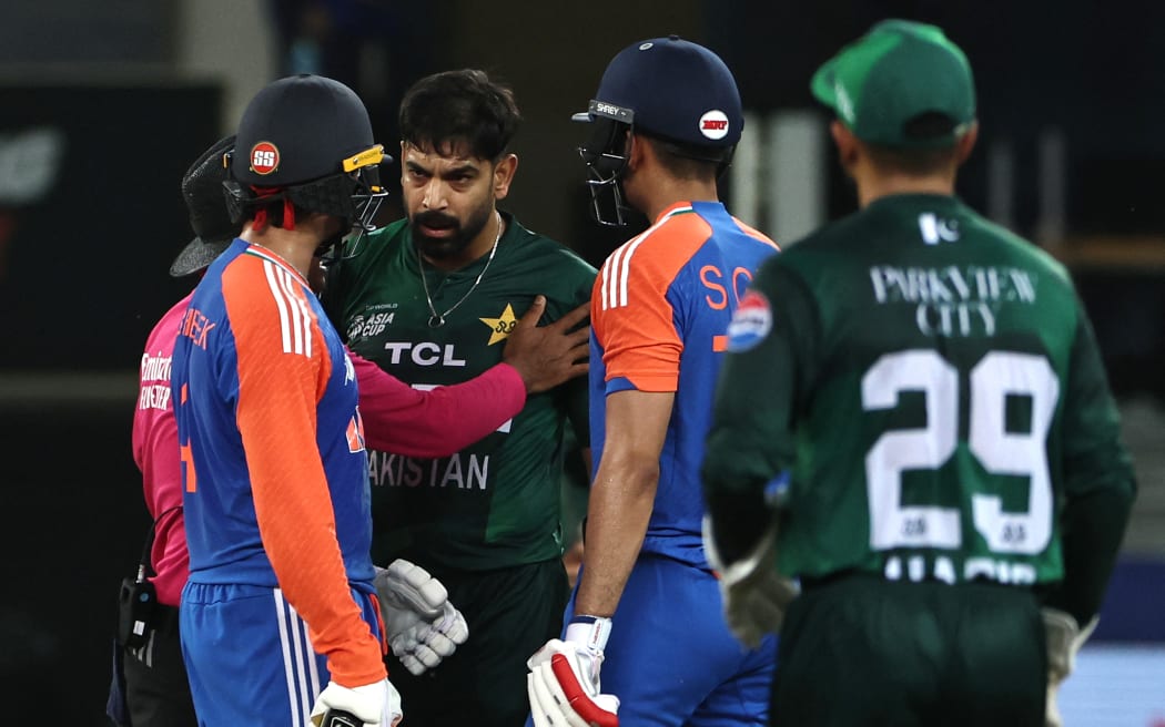 Pakistan's Haris Rauf speaks with India's Abhishek Sharma (L).