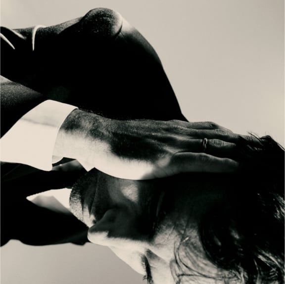 Cover image of Andrew Bird's album 'Inside Problems'. Portrays Bird on his side with hand to head.