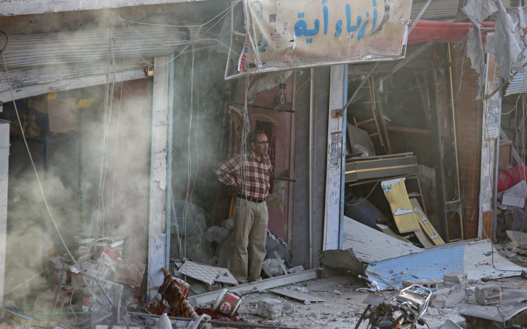 A Syrian man inspects the site of a car bomb explosion in the northern Syrian Kurdish town of Tal Abyad, on the border with Turkey, on November 2, 2019.
