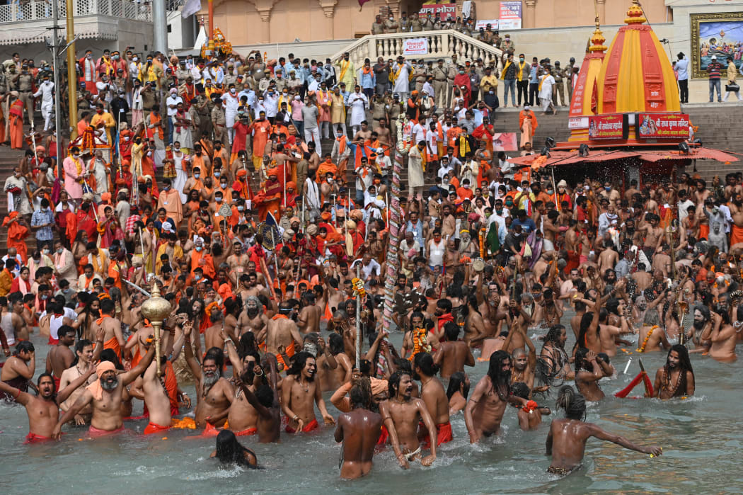 Naga Sadhus (Hindu holy men) take a holy dip in the waters of the Ganges River on the day of Shahi Snan (royal bath) during the ongoing religious Kumbh Mela festival, in Haridwar on April 12, 2021.