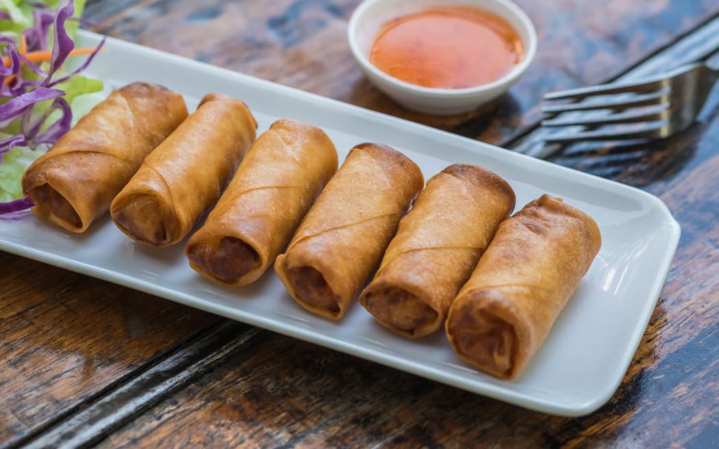 Deep fried spring rolls and vegetables on plate