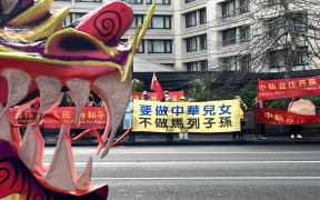 Protestors stand outside the Cordis Hotel in Auckland on Friday, June 14