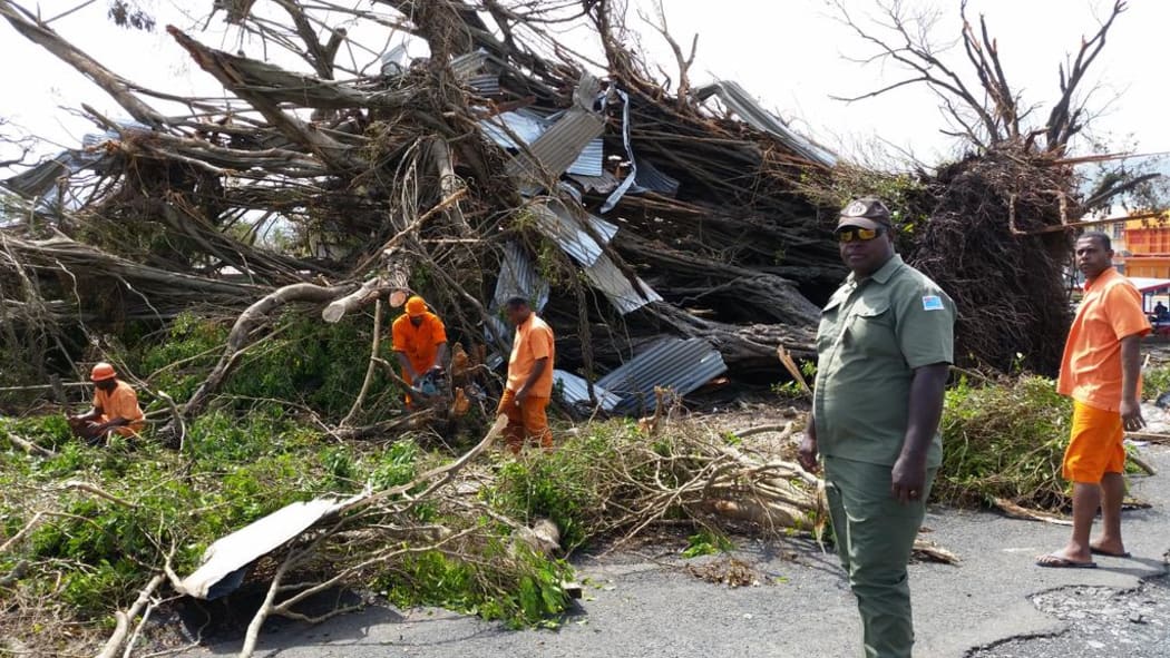 Inmates from Lautoka Correctional Centre are supervised while at work on the Vaileka  town in Rakiraki, Fiji, in the aftermath of Cyclone Winston.