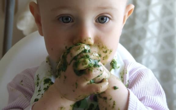 Baby eating green food