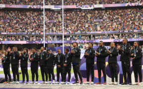 Silver medallists Fiji applaud on the podium after losing to France in the men's sevens final at the Paris Olympics.  27July 2024.