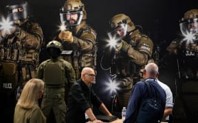 Visitors look at rifles during the Defence and Security Equipment International (DSEI) fair in London, on 12 September, 2023.