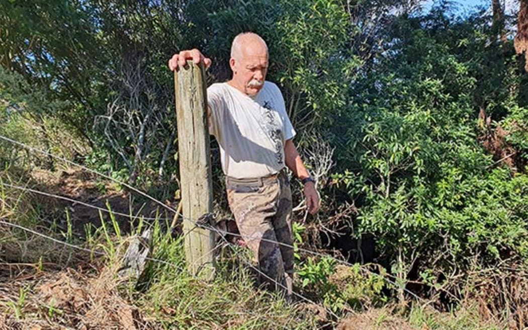 Steve McCann shows an area where forest has been trampled by stock.