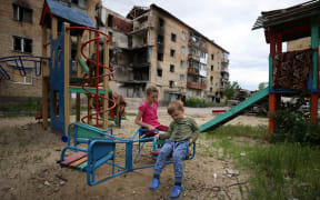 Children play in front of a bombed out apartment in the village of Horenka which is on the north-west border of Kyiv city on 5 June 2022.