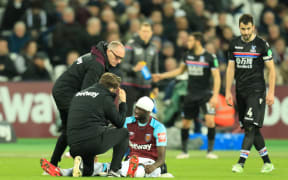 Cheikhou Kouyate of West Ham United is checked by the doctor after having his head bandaged