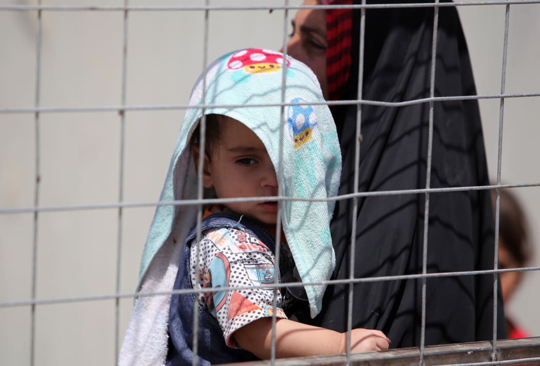 A child - part of a group of Sunni Iraqis fleeing violence in Ramadi - waits in the outskirts of Baghdad in April 2015.