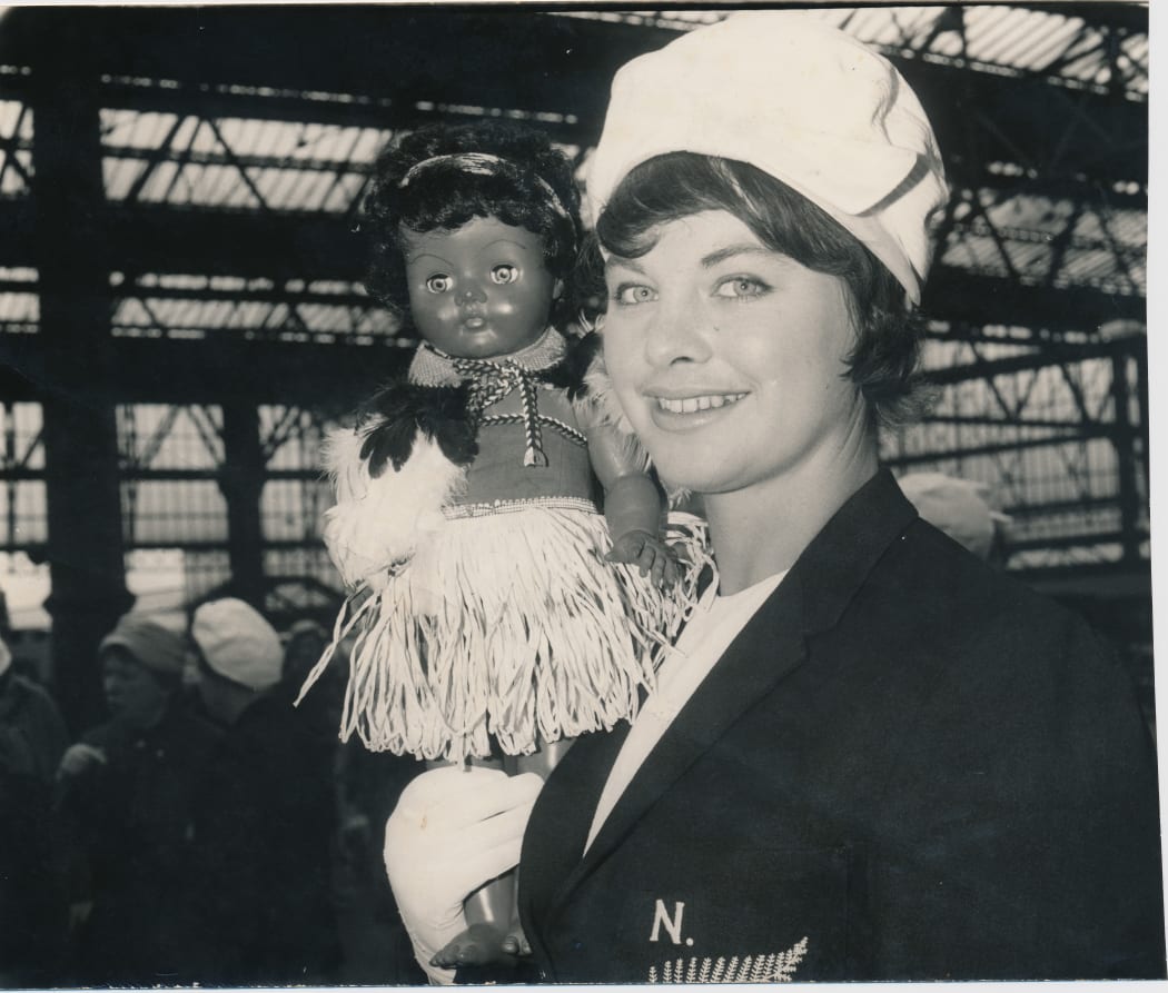 Joan Harnett on tour for the Silver Ferns, holding the team's mascot.
