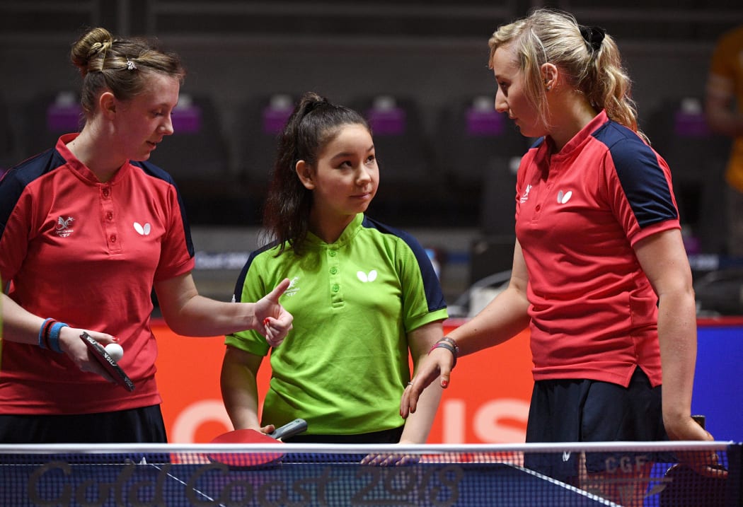 A photo taken on on April 2, 2018 shows eleven-year-old table tennis player Anna Hursey of Wales (C) sharing a lighter moment ith teammates Chloe Thomas (L) and Charlotte Carey (R) during training