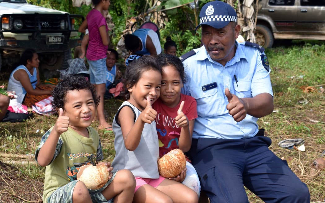 A Solomon Islands police officer with children in Rennel and Bollona province.
