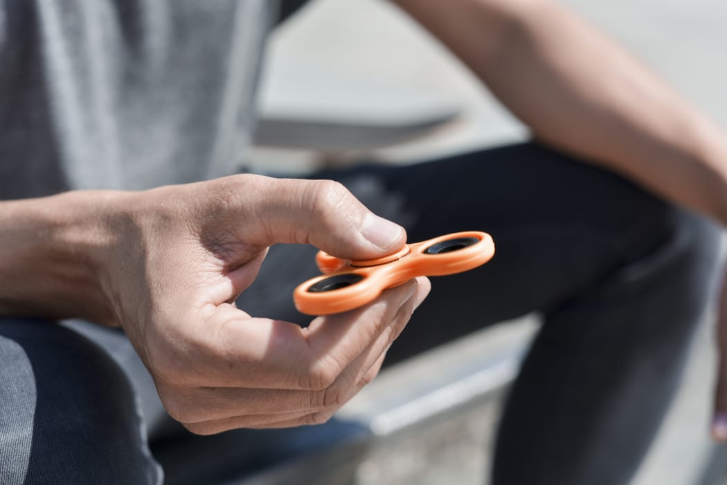 A man playing with a fidget spinner.