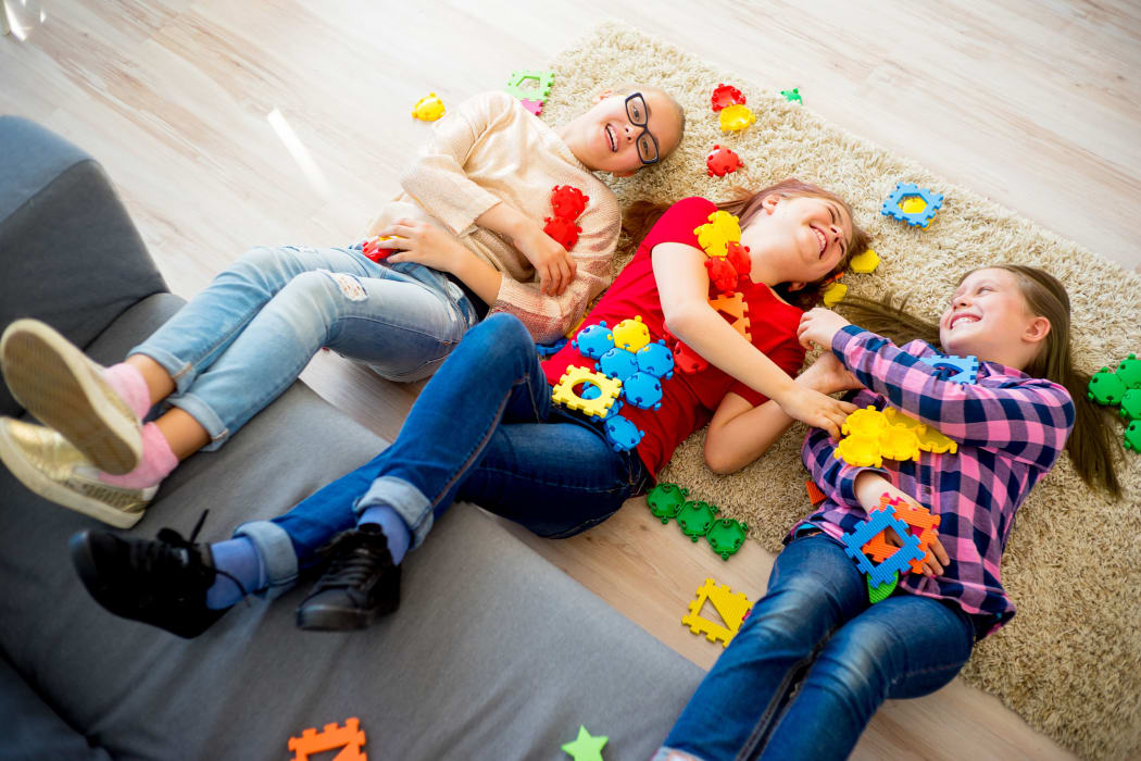 Portrait of three teen friends playing lego together