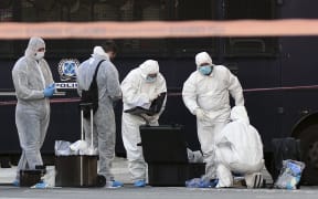 Police officers examine the entrance to the French embassy in central Athens, after two motorcyclists threw a hand granade and injured the guard, early on November 10, 2016.