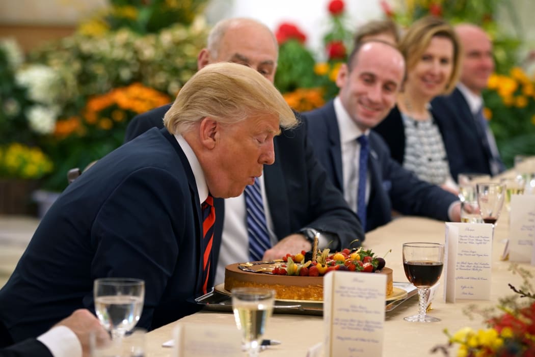 President Donald Trump blowing out a candle on his birthday cake.