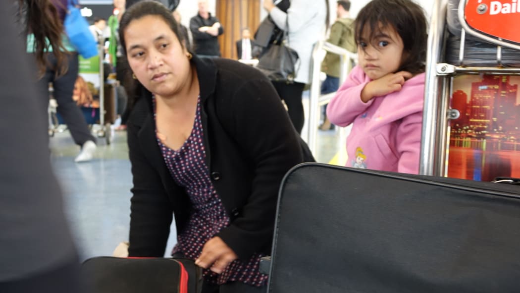 Ioane Teitiota's wife, Angua Erika, with one of the couple's three children at Auckland International Airport.