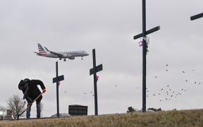 Roberto Marquez from Dallas, Texas, sets up a makeshift memorial on 31 January for the victims of the deadly midair collision near Reagan National Airport in Arlington, Virginia.