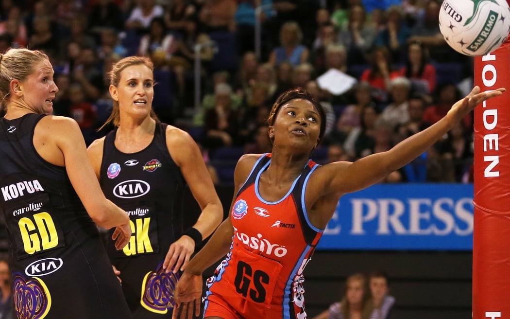 Mwai Kumwenda of the Tactix tries to keep the ball in the court watched on by Waikato Bay of Plenty Magic defenders Casey Kopua and Leana de Bruin.