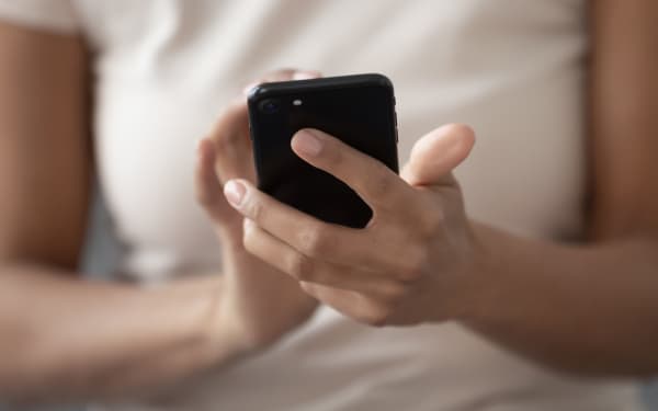 Close up of african American woman hold modern cellphone texting messaging with friends, black millennial female using smartphone browsing internet connection, surfing web. Technology concept