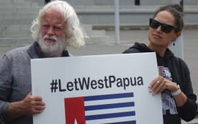 Emalani Case (right) holds a placard at the rally.