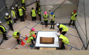 Auckland Museum staff carefully moving fragile kakahu (cloaks) to their new basement home through a purpose built tunnel to prevent damage from dust during recent construction work.
