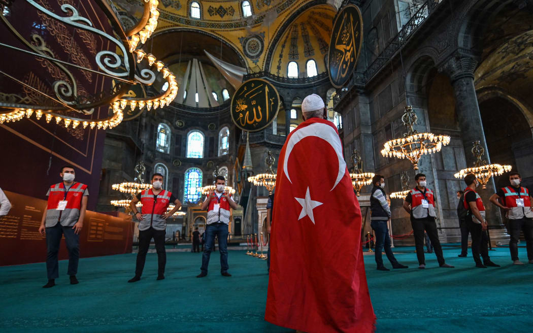 A man wrapped in a Turkish national flag visits the Hagia Sophia in Istanbul, on July 24, 2020, during the first Muslim prayers since the controversial reconversion of the iconic Istanbul cathedral into a mosque.