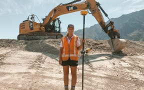 Olivia Thomson stands with a digger.