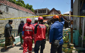 Rescuers walk in the cordoned off area at the Al Khoziny Islamic boarding school in Sidoarjo, East Java province on October 2, 2025, after a multi-storey building at the school collapsed. Rescuers detected "no more signs of life" under the rubble of a collapsed Indonesian school where 59 people remain missing, an official said on October 2, raising fears of a high death toll. (Photo by Juni KRISWANTO / AFP)