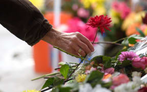 PITTSBURGH, PA - NOVEMBER 3: A visitor lays a flower on the makeshift memorial Saturday morning in front of the Tree of Life Synagogue on November 3, 2018 in Pittsburgh, Pennsylvania. Synagogues around Pittsburgh are opening their doors to members of the Tree Of Life congregation that was the target of a mass shooting that left 11 of its members dead on October 27.   Jeff Swensen/Getty Images/AFP (Photo by JEFF SWENSEN / GETTY IMAGES NORTH AMERICA / Getty Images via AFP)