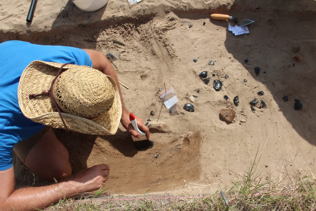 A University of Auckland archaeology student working at an excavation site on Ahuahu/Great Mercury Island during a University field research project.