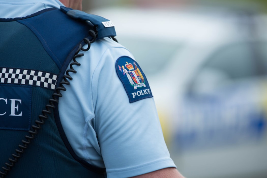 Close up of a police officer at an incident on a residential street. 6 July 2016.
