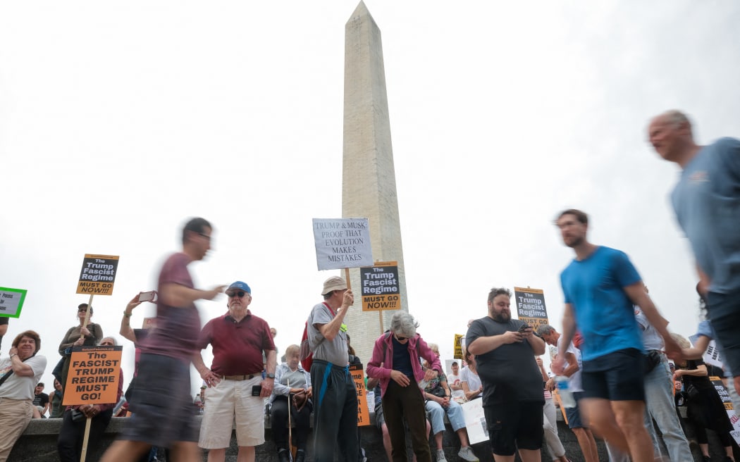WASHINGTON, DC - APRIL 19: Participants in the Anti-Trump protest shout and hold up signs on April 19, 2025 in Washington, DC. Organizers of the nationwide protest said the demonstrations were to denounce the "hostile government takeover" by the Trump administration.   Kayla Bartkowski/Getty Images/AFP (Photo by Kayla Bartkowski / GETTY IMAGES NORTH AMERICA / Getty Images via AFP)