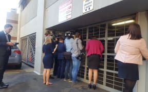 Political reporters peeking for clues through a garage door in the Beehive.